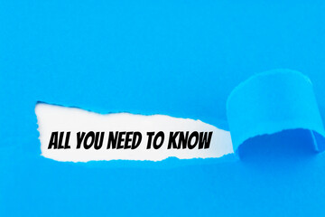Text All you need to know appearing behind ripped blue paper