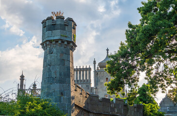 Fototapeta premium The walls and towers of the old palace on the background of a blue sky at sunset