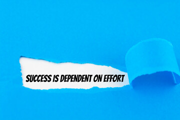 Text Success is dependent on effort appearing behind ripped blue paper