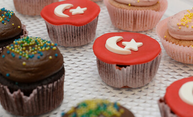 Turkish Flag on cakes. Delicious cupcakes on market shelf ready to eat variations of cakes. Horizontal high angle view of frosted cupcakes. Depth of field.
