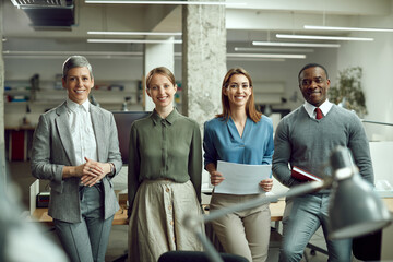 Portrait of happy multi-ethnic business team at corporate office looking at camera.