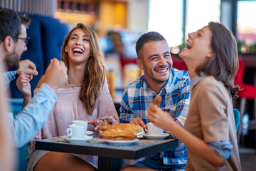 Cheerful  friends eating in cafe