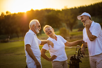 Three seniors golfers talking on golf field.  This was the perfect day for fun. - 434280198