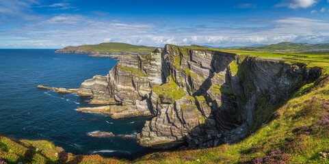 Large panorama with majestic tall Kerry Cliffs and turquoise coloured Atlantic Ocean on a sunny...