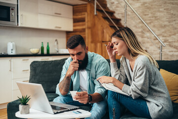 Couple using a laptop while working on their home finances