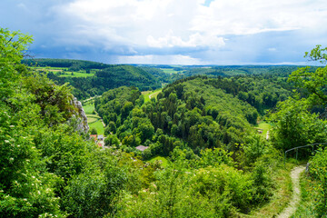 Fototapeta na wymiar Scenic view of a green valley and forested hills near the village of Gundelfingen, Germany. This beautiful countryside is part of the UNESCO Biosphere Reserve Swabian Alb in the south of Germany.