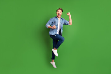 Full length body size photo of young guy jumping happy gesturing like winner cheerful isolated...