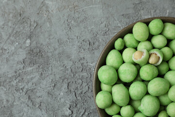 Bowl of wasabi nuts on gray textured background