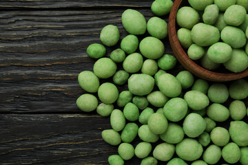 Bowl of wasabi nuts on rustic wooden background