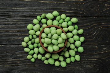 Bowl of wasabi nuts on rustic wooden background