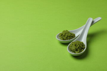 Ceramic spoons with wasabi on green background