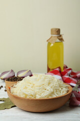 Obraz na płótnie Canvas Fresh sauerkraut and ingredients on white wooden table