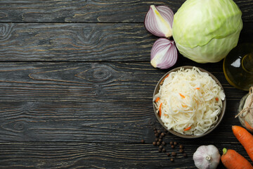 Fresh sauerkraut and ingredients on wooden table