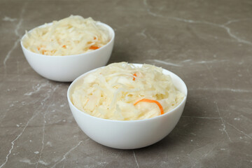 Bowls of sauerkraut on gray textured background
