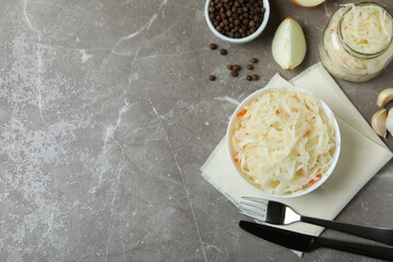 Fresh sauerkraut and ingredients on gray textured table