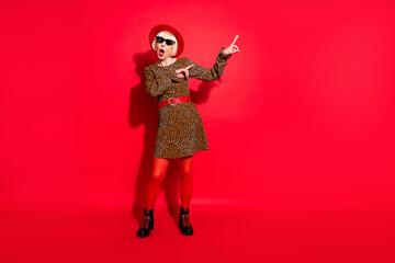 Full length photo of shocked amazed old woman dance good mood point finger isolated on red color background