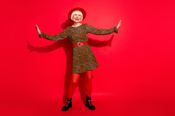Full length photo of cheerful aged woman happy positive smile have fun isolated over red color background