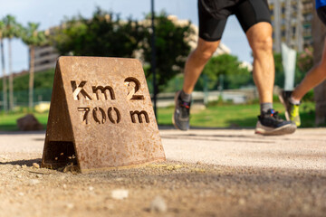 Primer plano de un letrero de 700 m de Km 2 sobre un fondo borroso de un hombre corriente irreconocible