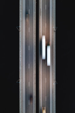 Aerial long exposure top down view of fast traffic vehicles on the highway bridge at night, Kaunas, Lithuania.