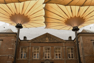 Hoeselt, Limburg - Belgium - 13.05.2021. Domed rain canopies in the courtyard of an ancient castle with a water intake inside. Alden Biesen. Belgium