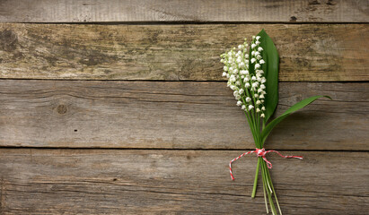 bouquet of blooming lilies of the valley on a gray wooden background