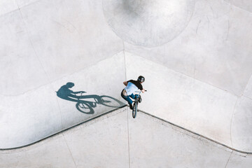 Aerial view of BMX bike rider doing turn down trick in local skatepark in Panevezys, Lithuania.