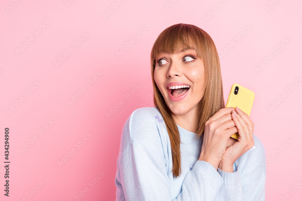 Poster portrait of attractive cheerful girl using gadget looking aside copy space offer idea roaming isolat