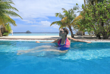 girl in a bikini by a palm tree in a tropical resort