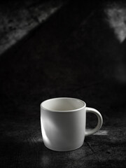 Obraz na płótnie Canvas White empty coffee mug on black stone background