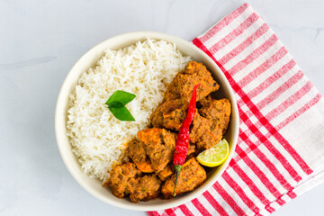 South Indian Stir-Fried Chicken with Rice in a Bowl Garnished with Curry Leaves Horizontal Top Down Photo