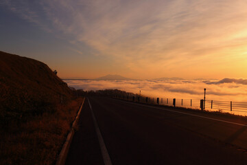 雲の上を走る峠道とその先に見える藻琴山