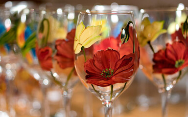 Closeup shot of painted yellow and red tulips on the wine glasses