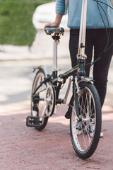 Obraz premium Woman next to a bicycle in the street