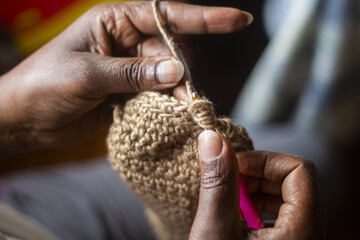 Close up of a woman's hand crocheting. - obrazy, fototapety, plakaty