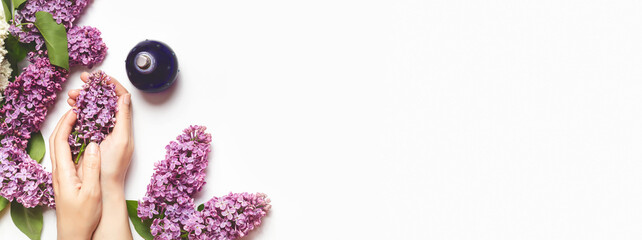 perfumery and flower aroma concept. femalehands hold a branch of lilac on a white background. perfume with lilac scent. copy space. banner - obrazy, fototapety, plakaty