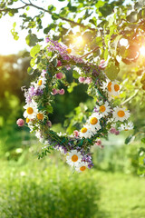 wreath of wild Meadow flower in garden. beautiful summer season. Summer Solstice Day, Midsummer concept. floral traditional decor. pagan witch traditions, wiccan symbol and rituals - obrazy, fototapety, plakaty