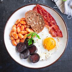 english breakfast fried egg black pudding blood sausage, cereal bread, beans, bacon, scrambled...