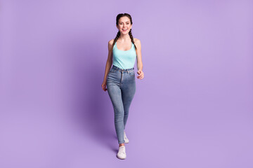 Full length body size view of attractive cheerful content girl walking isolated over violet purple color background