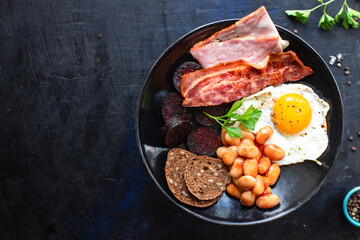 english breakfast fried egg black pudding blood sausage, cereal bread, beans, bacon, scrambled eggs, wholesome food healthy meal snack copy space food background rustic top view