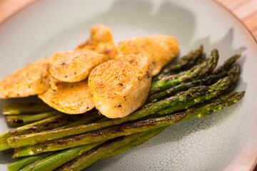 cooked dish. Chicken nuggets with green asparagus on plate