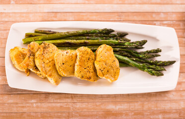 cooked dish. Chicken nuggets with green asparagus on plate