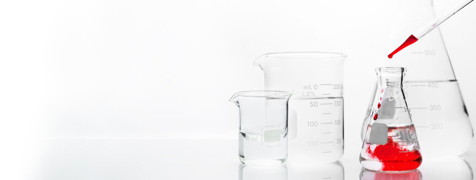 glass flask and beaker with orange drop solution in chemistry science research lab white banner background