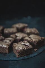 Tasty vegetarian brownie made from chocolate and cacao. Delicious chocolate pie. Selective focus. Flat lay composition with fresh brownies on dark background. Homemade dessert. No sugar pastry