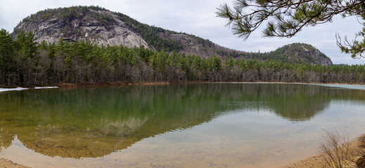 Mountain reflected in a still green pond