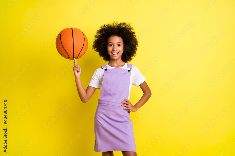 Sticker photo of funny little girl spinning ball finger open mouth wear purple overall isolated yellow color