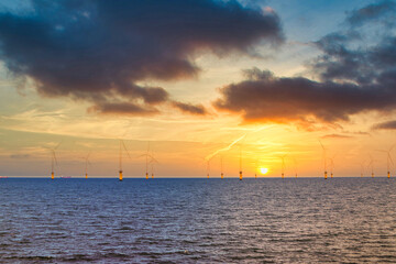 Fototapeta na wymiar Offshore Wind Turbine in a Windfarm under construction off the England Coast at sunset