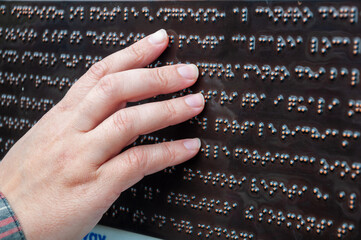 a blind person reads braille, female hand touch the characters
