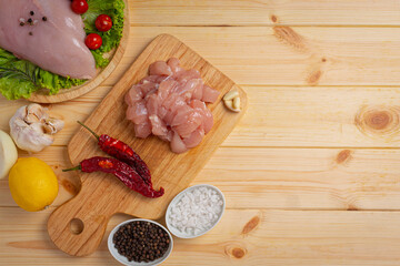 Raw chicken breast on the wooden background.