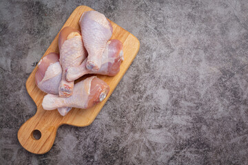 Raw uncooked chicken legs on the dark background.