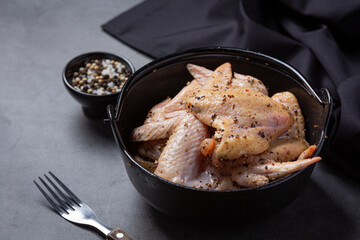 Raw chicken wings on the dark background.